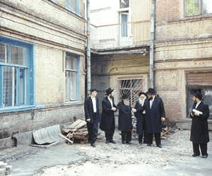 РЕБ ЗАЛМАН (В ЦЕНТРЕ) ПОДНИМАЕТСЯ ИЗ ПОДВАЛА, ГДЕ РАСПОЛАГАЛАСЬ МИКВА, ВО ДВОРЕ ДОМА, В КОТОРОМ ЖИЛИ РЕБЕ РАШАБ И РЕБЕ РАЯЦ В РОСТОВЕ.